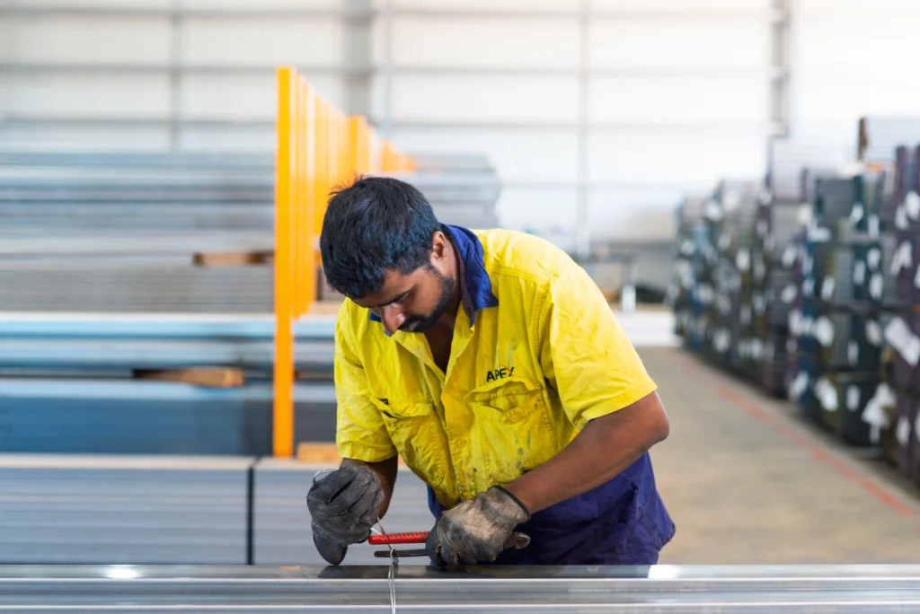 Local steel worker tying up knots on steel - Local Business APEX Steel Supplies