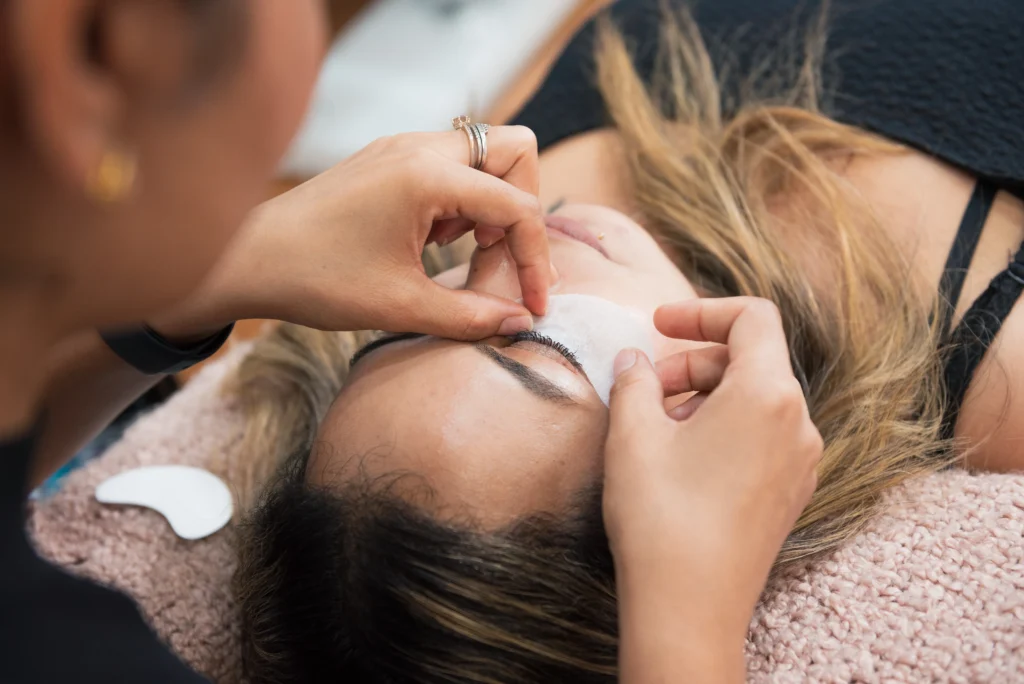 Lash tech applying under eye tape before service - commercial photography